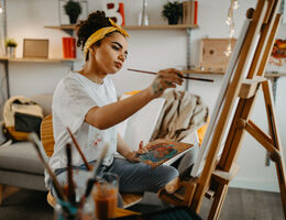 A woman paints at an easel.