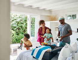 A family unpacks their beach supplies in a vacation rental.